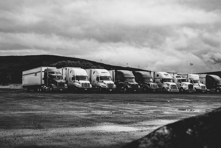 Row of commercial trucks parked at a logistics yard