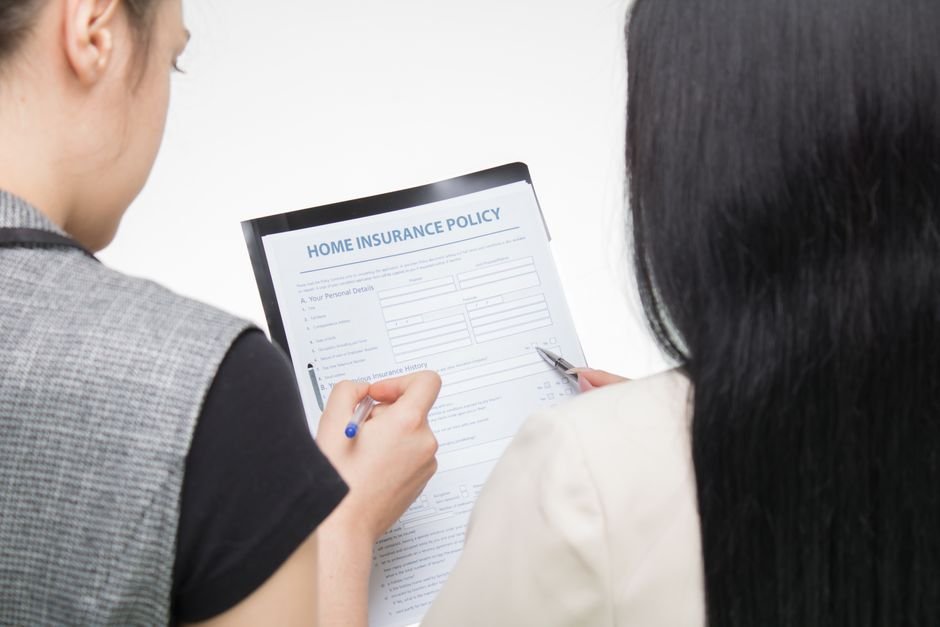 Insurance claim form on a clipboard beside a car